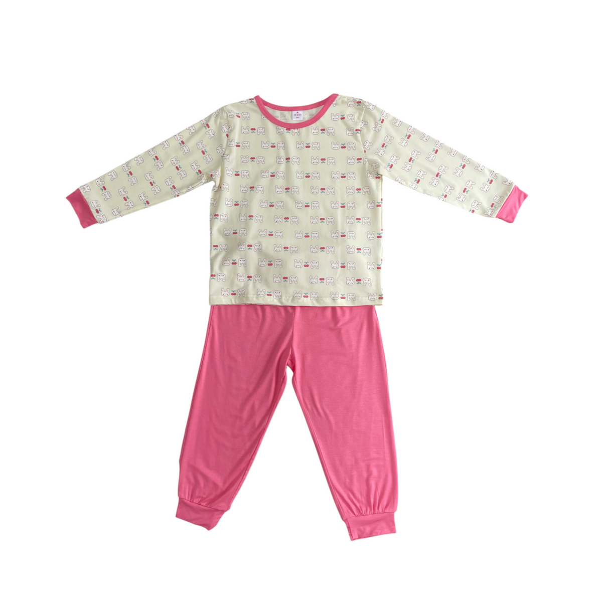A children's two-piece pajama set laid flat on a white background, featuring a long-sleeve top with a cream base, pink trim at the collar and cuffs, and a small repeating pattern, paired with solid pink pants.